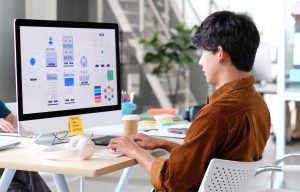 homem mexe em computador com ícones de organização coloridos.