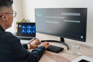 Pessoa digita em computador com tela aberta em chat de IA.
