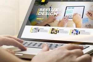 Designer de software acessando um site de UX Design pelo notebook.